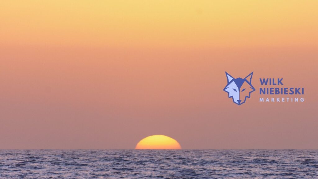 morze na tle zachodzącego słońca a na tym logo agencji marketingowej w Warszawie - Wilk Niebieski